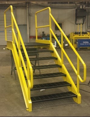 Custom metal staircase with yellow railings in a warehouse space