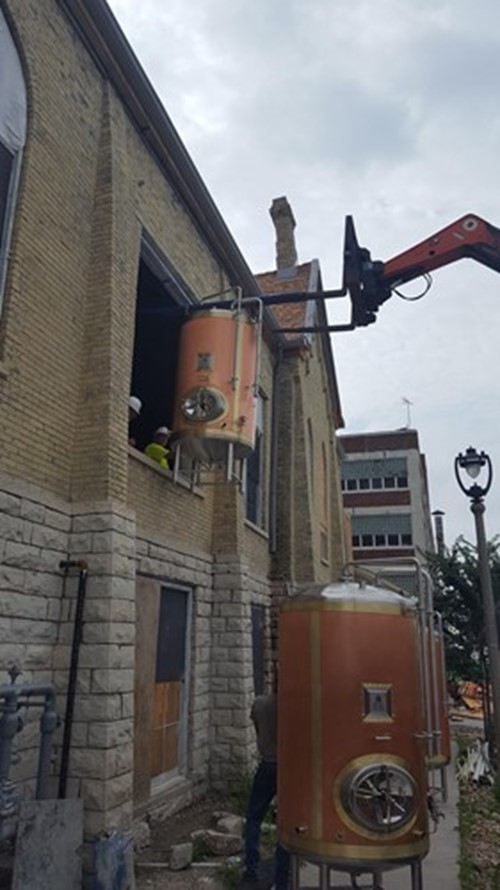 A forklift crane rigging tanks into a second floor window at the Pabst Brewing Company in Downtown Milwaukee