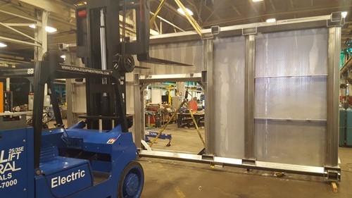 An electric forklift and overhead crane moving a stainless steel platform